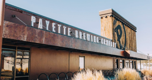 Exterior of Payette Brewing Company with a rustic design and large sign against a clear blue sky.