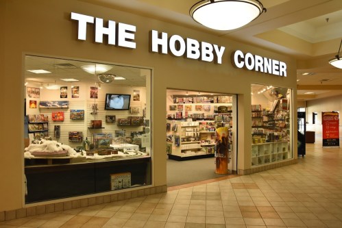 A storefront labeled "The Hobby Corner," showcasing various hobby supplies and merchandise inside.
