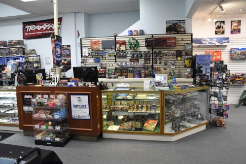 A retail store display featuring a counter with glass cases, showcasing various hobby items and merchandise.