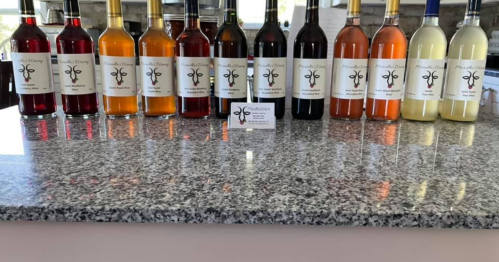 A variety of colorful bottles of wine displayed on a granite countertop, with a business card in front.
