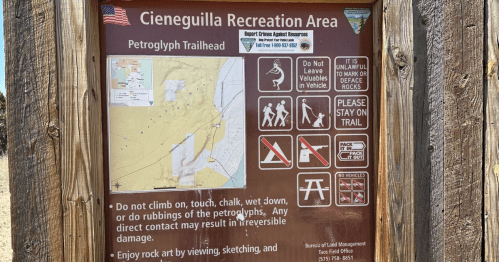 Sign at Cieneguilla Recreation Area with map and guidelines for visiting the Petroglyph Trailhead.