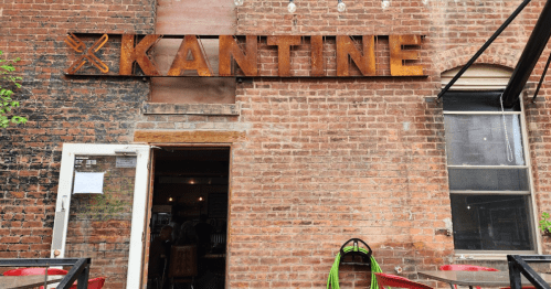 Exterior of a restaurant named "Kantine," featuring a brick wall and a welcoming entrance.