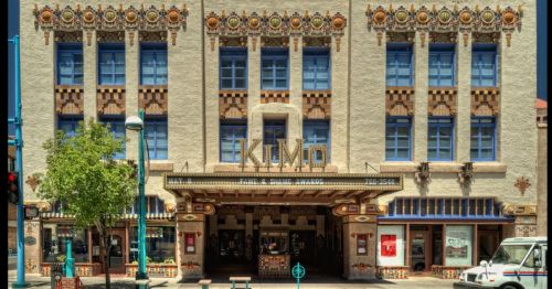 Historic Kimo Theatre facade featuring colorful architectural details and vibrant blue windows.