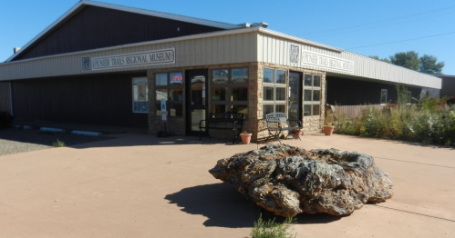 Exterior of the Center Trails Regional Museum, featuring a large rock sculpture in front and a welcoming entrance.