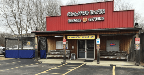 Exterior of Crawfish Haven, a seafood restaurant with a red roof and wooden accents, featuring an "Open" sign.