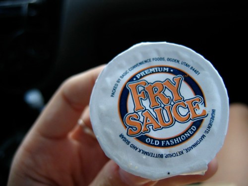 A hand holding a container of "Fry Sauce" with a label that reads "Premium Old Fashioned."