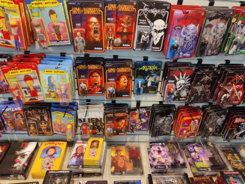 A display of collectible action figures and toys, featuring various horror and metal-themed characters and bands.