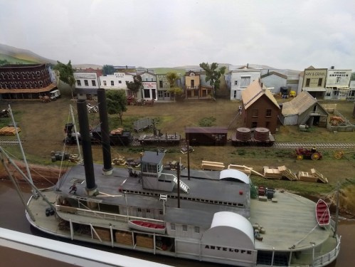 A detailed model of a steamboat named "Antelope" in a miniature town with buildings, trees, and a railway.