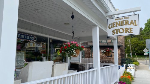 A charming general store with hanging flower baskets and a welcoming sign, located in Watch Hill.