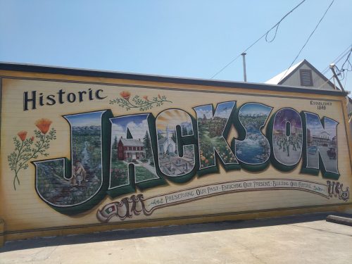 Colorful mural reading "Historic Jackson" with images of local landmarks and flowers, celebrating the town's heritage.