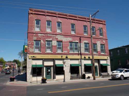 Historic red brick building with large windows, featuring a restaurant on the ground floor and a clear blue sky above.