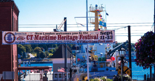 Banner welcoming visitors to the CT Maritime Heritage Festival, with boats and a harbor in the background.