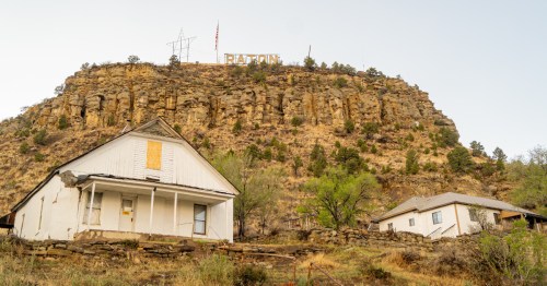 Houses on a mountainside just under the Raton sign in Raton, New Mexico.
