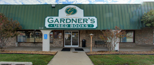 Front view of Gardner's Used Books store, featuring a green roof and large sign, with a welcoming entrance.