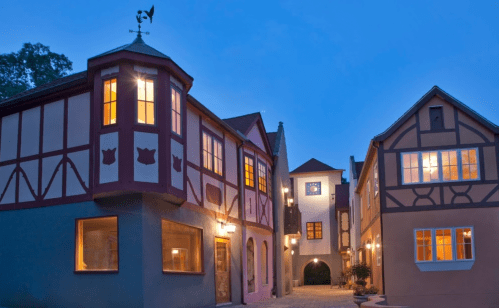 Charming buildings with colorful facades and warm lights, set against a twilight sky.