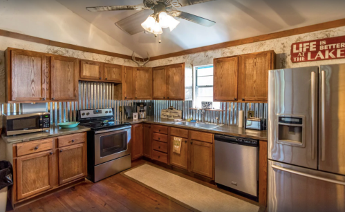 Cozy kitchen with wooden cabinets, stainless steel appliances, and a rustic decor featuring corrugated metal accents.