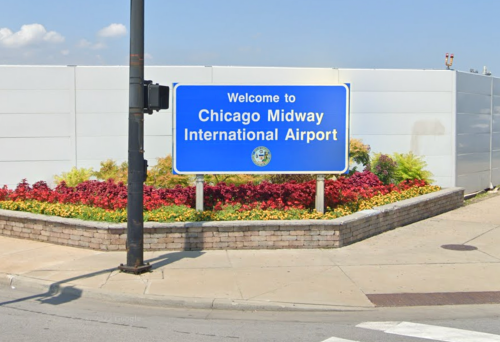 Welcome sign for Chicago Midway International Airport, surrounded by colorful flowers and greenery.