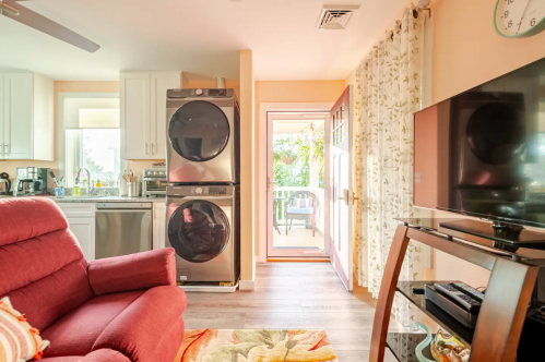 Cozy living space featuring a red recliner, modern appliances, and a view of a patio through a glass door.