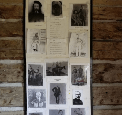 A collage of historical black-and-white photos and documents displayed on a wooden wall.