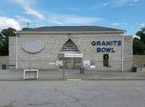 Exterior view of Granite Bowl, featuring a stone facade and signage for the 1995 AA State Champions.