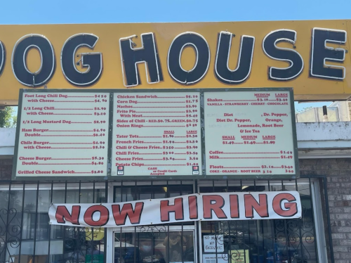 Menu board for "Dog House" featuring various food items and prices, with a "Now Hiring" banner at the bottom.