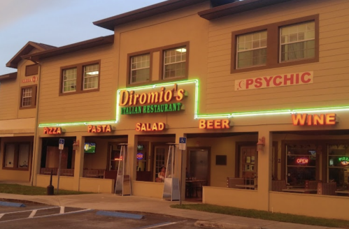 Exterior of Diromio's Italian Restaurant, featuring neon signs for pizza, pasta, salad, beer, and wine.