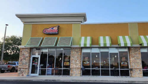 Exterior of a Citarella store with a stone facade and green-striped awnings, featuring large glass windows.