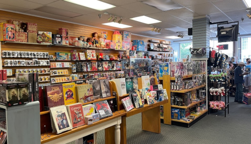 A colorful store interior filled with shelves of toys, collectibles, and merchandise, with customers browsing.