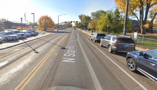 A view of N Star Rd with parked cars on the right and trees displaying autumn colors lining the street.