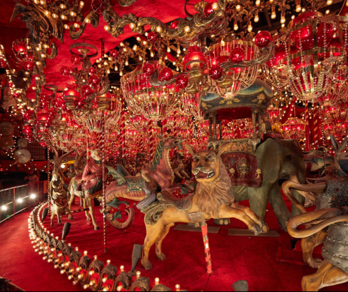 A vibrant carousel adorned with colorful lights and ornate decorations, featuring various whimsical animal figures.