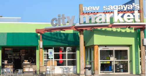 Exterior of New Sagaya's City Market, featuring a green facade and large sign, with shoppers visible inside.