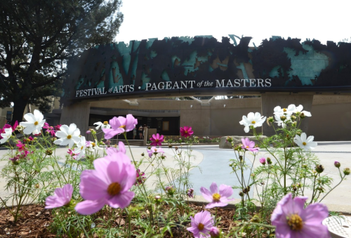 Entrance to the Festival of Arts Pageant of the Masters, surrounded by colorful flowers in bloom.