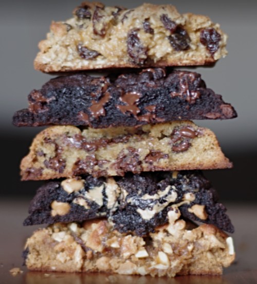 A stack of five different cookie varieties, showcasing layers of chocolate, nuts, and oats.
