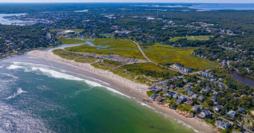 aerial shot of the long stretch of sand and the water at good harbor beach in gloucester massachusetts