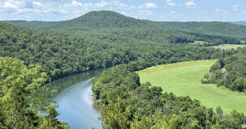A mountain and river view from the Ozark Highlands Trail, one of the best hikes in Arkansas.