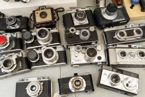A collection of vintage cameras displayed on a table, featuring various styles and designs.