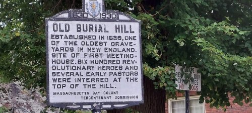 Sign for Old Burial Hill, established in 1680, noting its historical significance and burial of Revolutionary heroes.