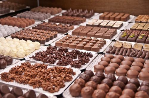 A variety of chocolates and confections displayed on trays, including truffles, pralines, and chocolate-covered treats.