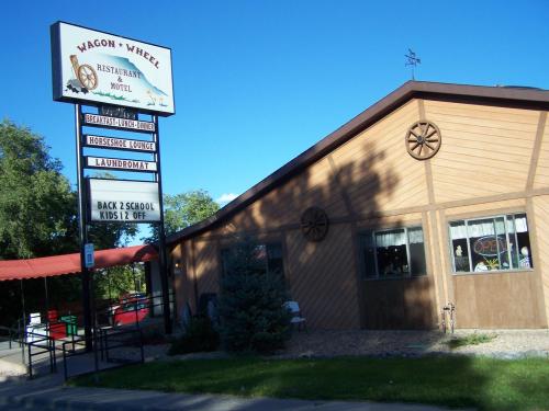 Sign for Wagon Wheel Restaurant & Motel, featuring a wooden exterior, open sign, and nearby amenities like a laundromat.