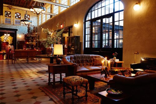 Cozy interior of a stylish lounge with leather sofas, warm lighting, and decorative elements, creating an inviting atmosphere.