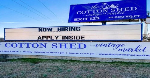 Sign for The Cotton Shed Vintage Market advertising job openings with "Now Hiring" and "Apply Inside."