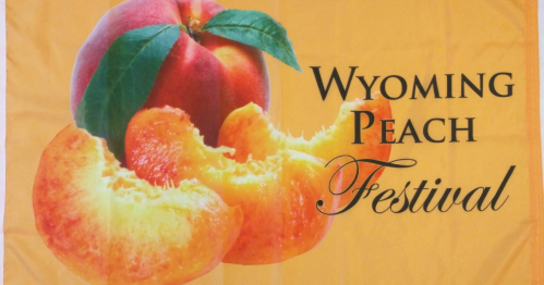A vibrant banner featuring a peach and peach slices with the text "Wyoming Peach Festival."