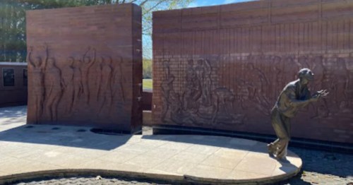 Outdoor brick memorial wall and bronze prisoner statue at the Andersonville Museum - GA.
