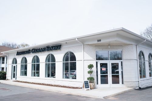Exterior of Annette's German Bakery, featuring large arched windows and a welcoming entrance.