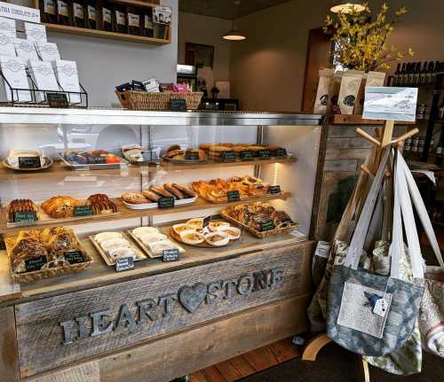 A cozy bakery display featuring various pastries and baked goods, with a rustic wooden counter and decorative items.