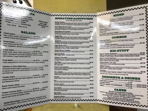Menu board featuring salads, signature sandwiches, sides, combos, desserts, and drinks with prices listed.