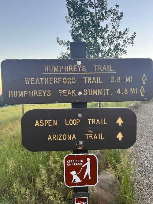 Trail sign indicating directions and distances for Humphreys Trail, Weatherford Trail, Aspen Loop Trail, and Arizona Trail.