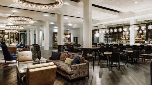 Elegant lounge with plush seating, modern decor, and a stylish bar featuring pendant lighting and a warm atmosphere.