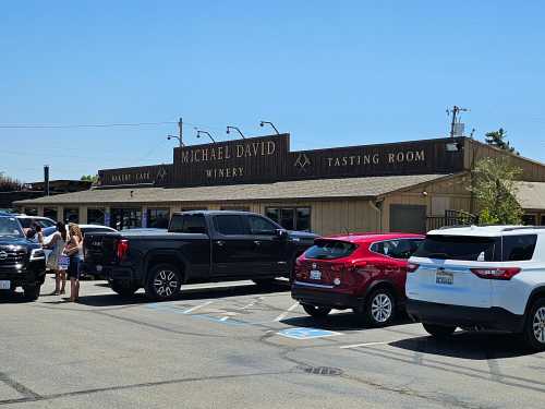 Exterior of Michael David Winery with a tasting room, featuring parked cars and visitors outside on a sunny day.