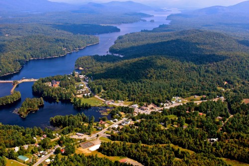 Aerial view of a lush, green landscape with lakes and a small town nestled among the trees.